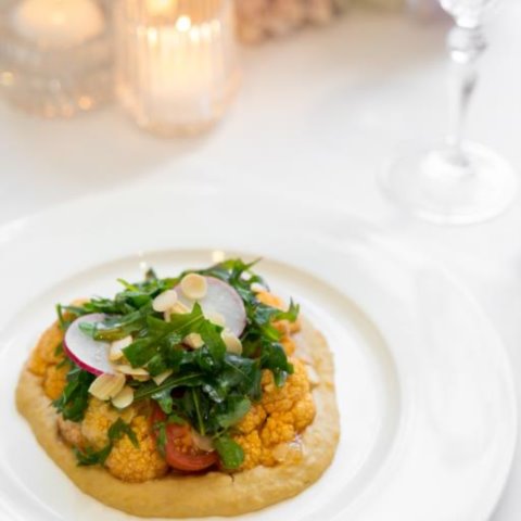 SPICED ROASTED CAULIFLOWER SALADRoasted Cauliflower marinated in Moroccan Spice Mix with Hummus, Eschalot, Almond, Cherry Tomato (GF, DF, V)